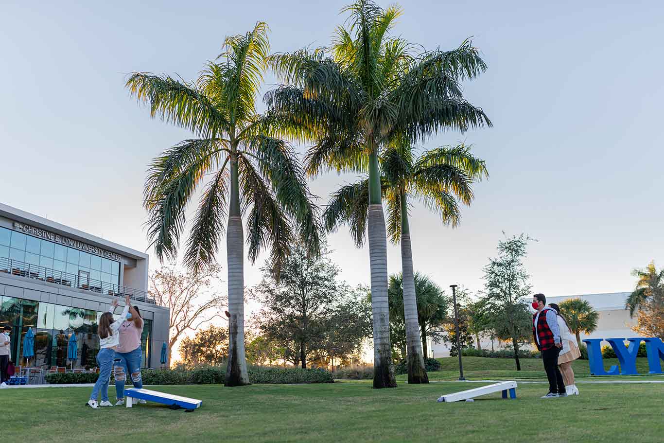 Students playing corn hole in the park